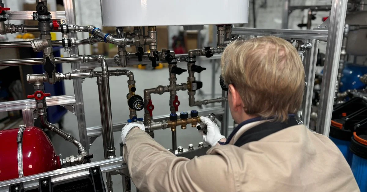 Ingeniero trabajando en el sistema de tuberías industriales en una fábrica para calefacción y ajuste de producción.