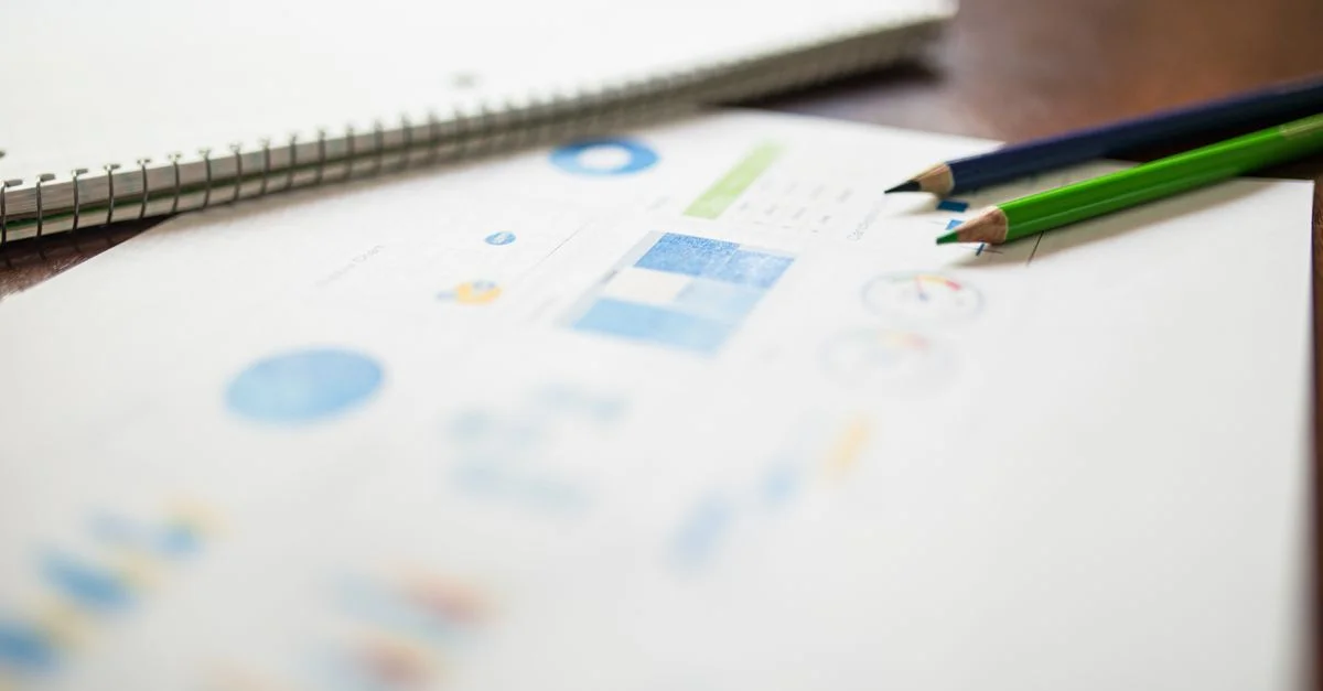 Acercamiento de lápices de colores en un informe analítico para fines educativos o comerciales.