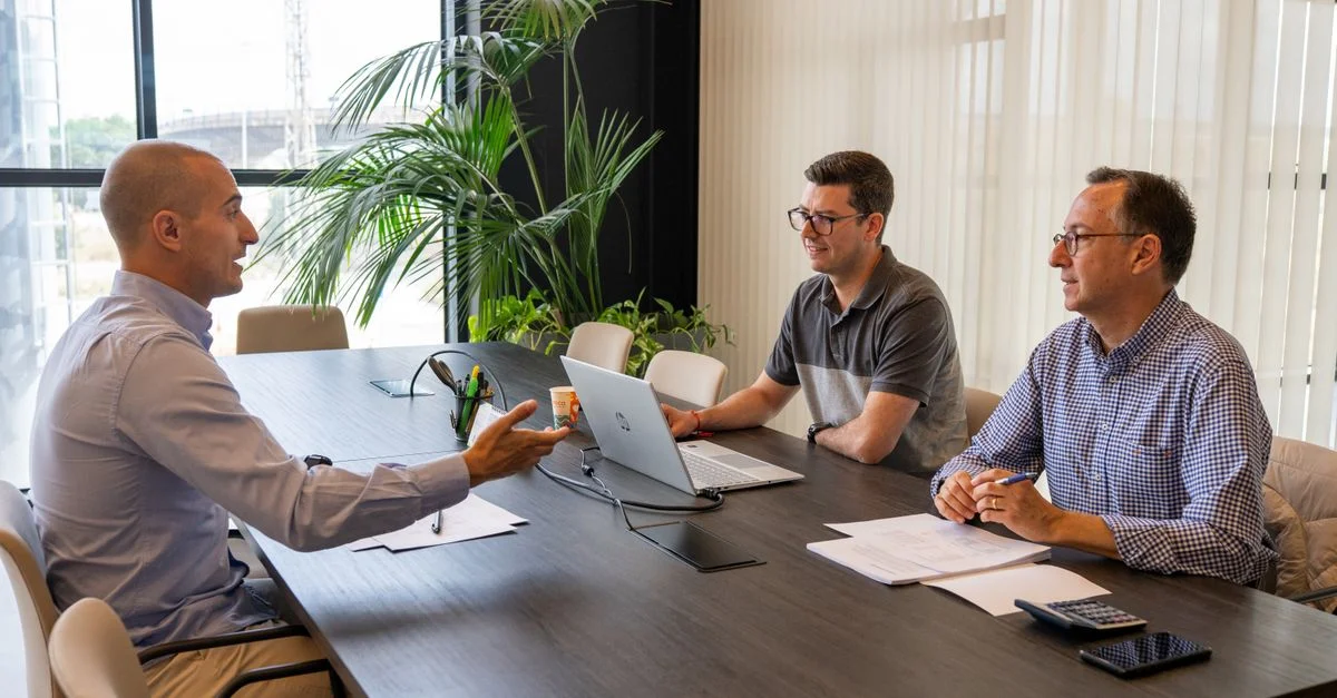 Profesionales participan en una reunión de negocios colaborativa en un entorno de oficina moderno.