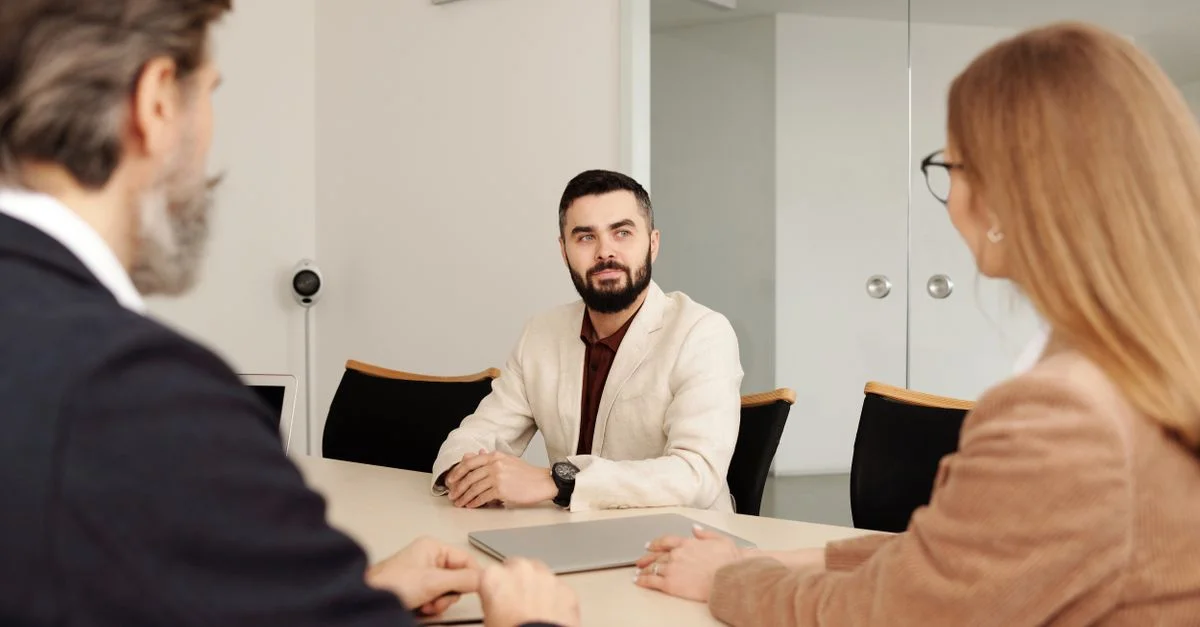 Reunión de negocios profesional con miembros de un equipo diverso en un entorno de oficina.