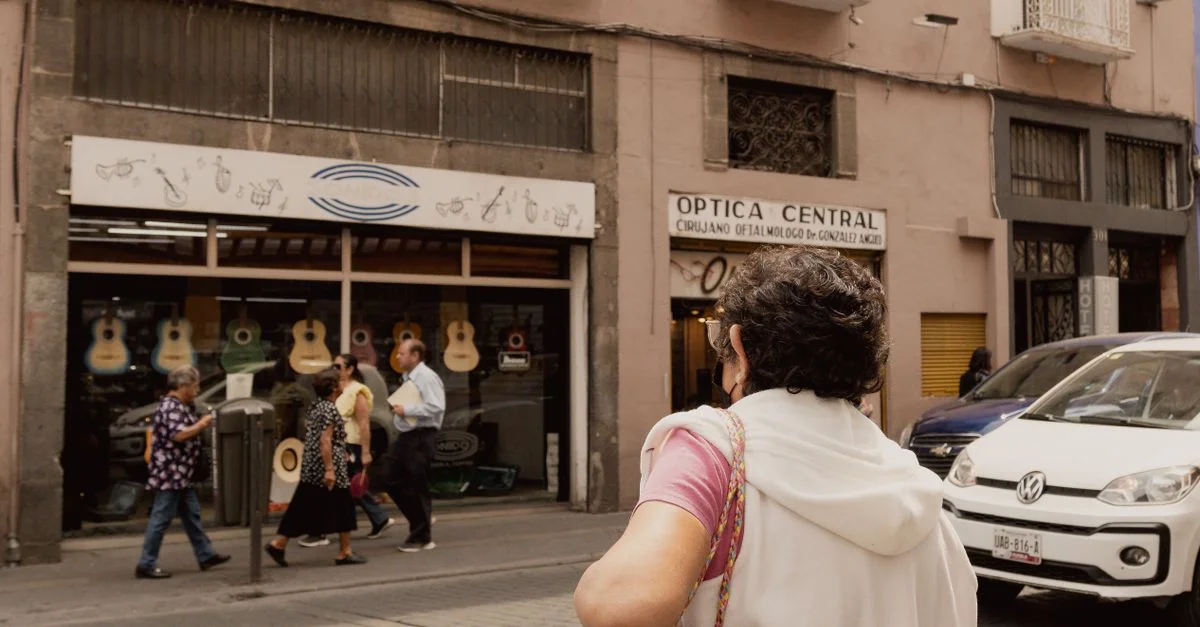 Una calle bulliciosa en Puebla, México, con peatones y tiendas locales.