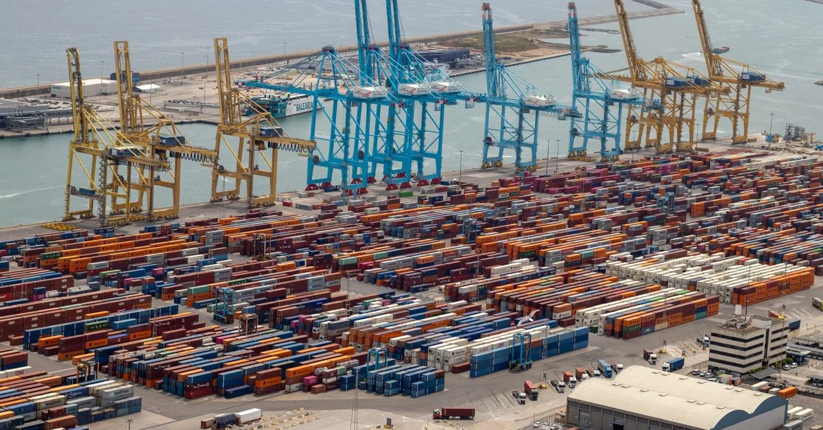 Un puerto bullicioso con contenedores de envío y grúas, que muestra el comercio global.