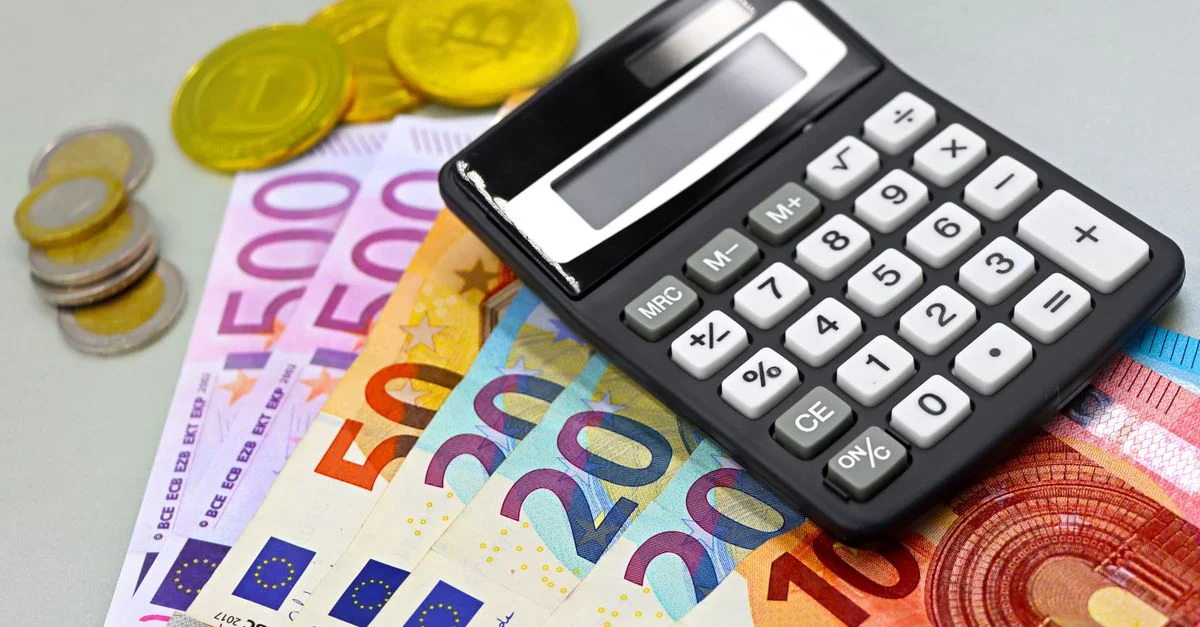 Imagen de billetes y monedas de euro y una calculadora para planificación financiera. Ideal para temas financieros.
