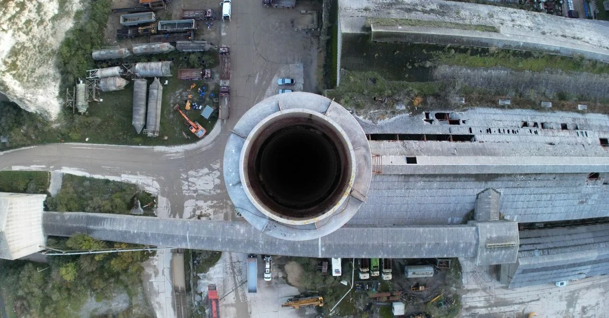 Toma de drone capturando una vista aérea de fábrica industrial y chimenea, mostrando la infraestructura industrial.