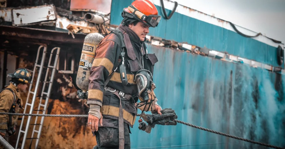Bomberos en acción apagando un incendio en un barco en Guayaquil, Ecuador, mostrando valentía y trabajo en equipo.
