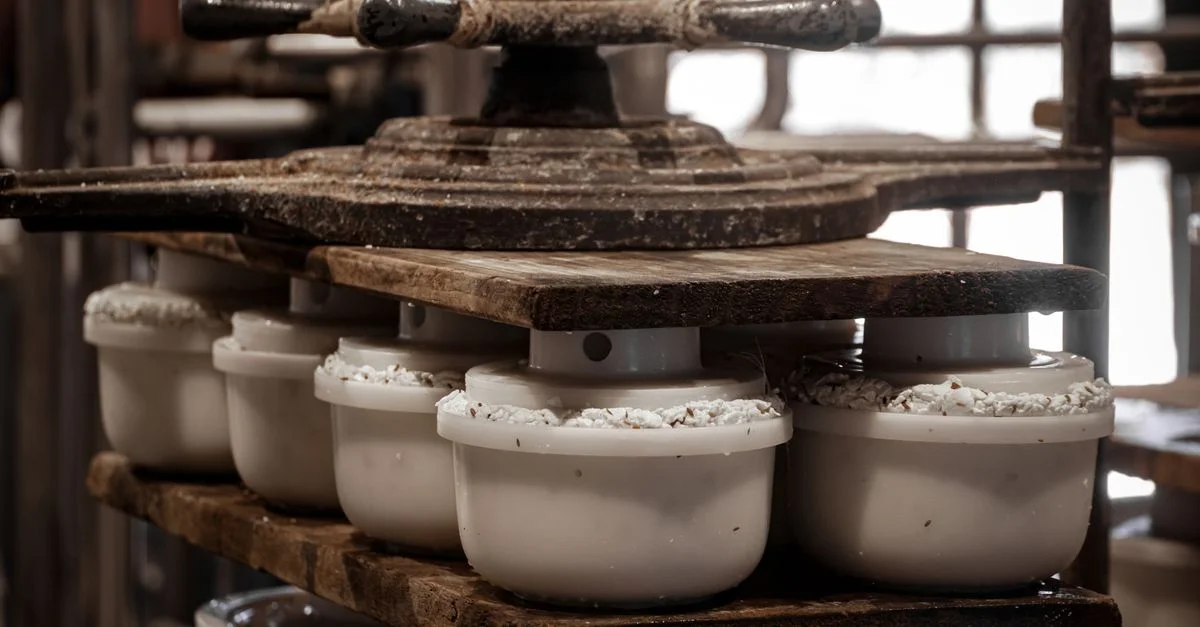 Close-up de moldes de queso durante el proceso tradicional de elaboración de queso en interiores.