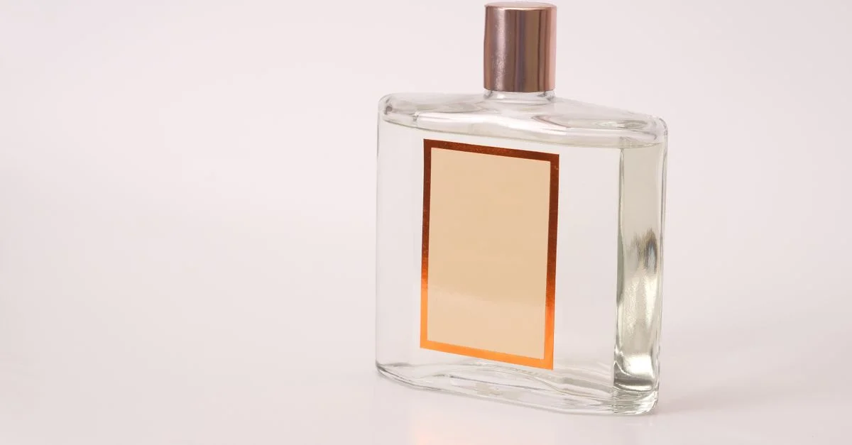 Un frasco de perfume transparente con etiqueta vacía, adecuado para branding o fines de diseño.