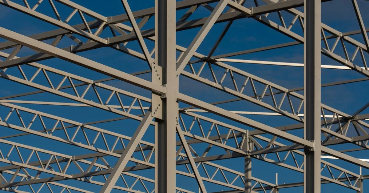 Vista detallada de una estructura de acero contra un cielo azul, mostrando elementos de construcción modernos.