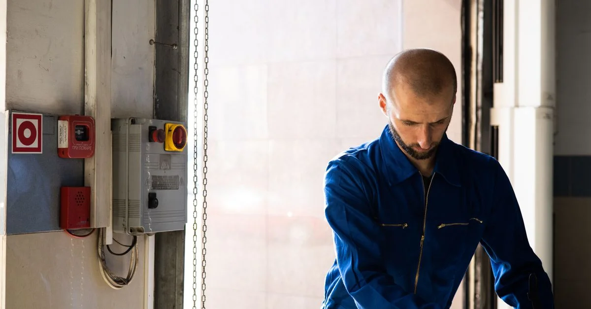Técnico caucásico trabajando en interiores con EPI en un entorno industrial.