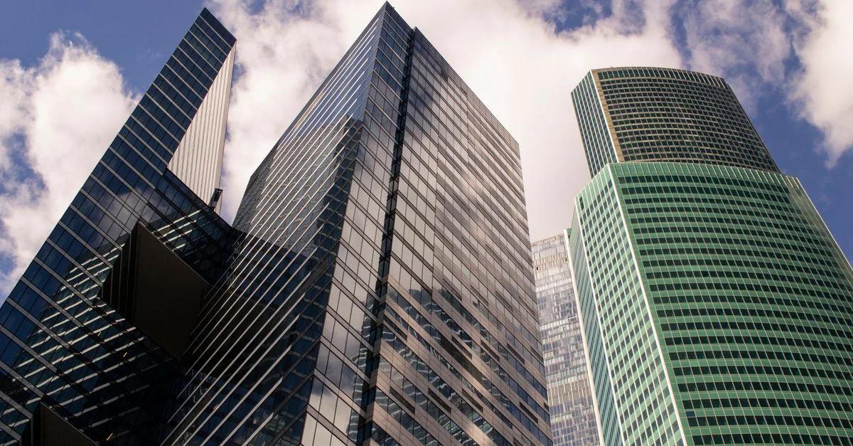 Una vista dramática de los modernos rascacielos de Moscú contra un cielo brillante, mostrando la arquitectura urbana.