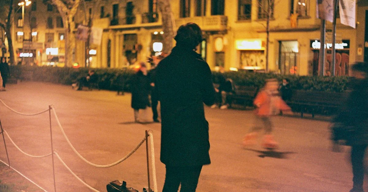 Un músico callejero toca el violín en una animada noche en Barcelona, España.