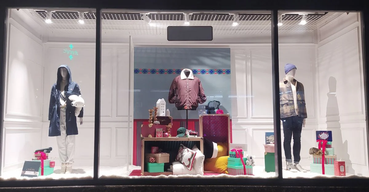 Exhibición estilosa de escaparate con trajes de invierno y cajas de regalos en Nancy, Grand Est, Francia.