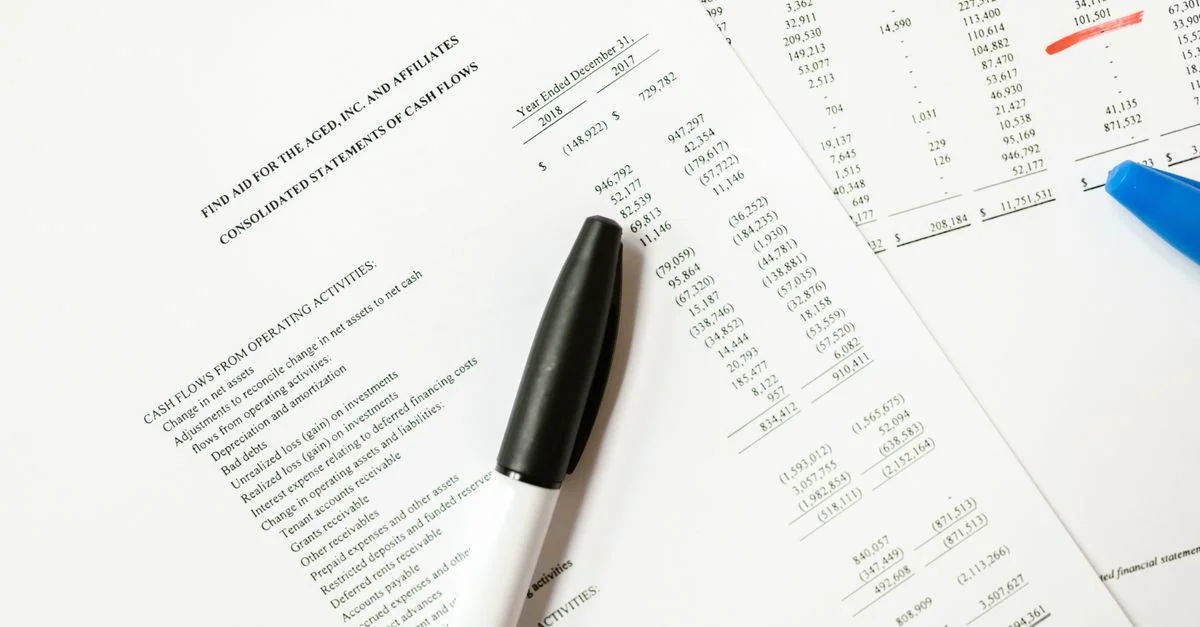 Documentos financieros con flujos de caja y bolígrafos, ideales para temas y análisis de negocios.