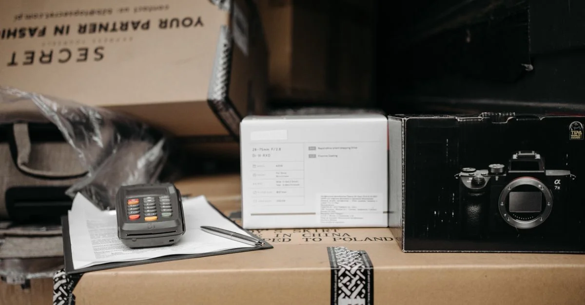 Paquetes variados con equipos de cámara listos para el envío en un entorno interior.