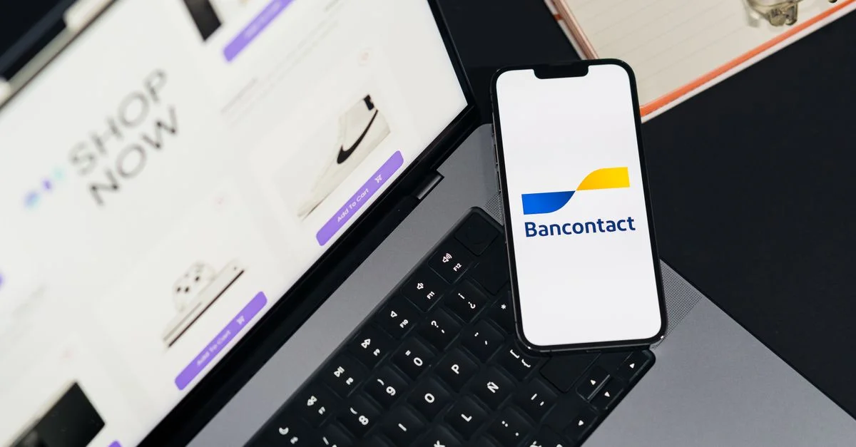 Smartphone que muestra la aplicación Bancontact en una computadora portátil durante las compras en línea.