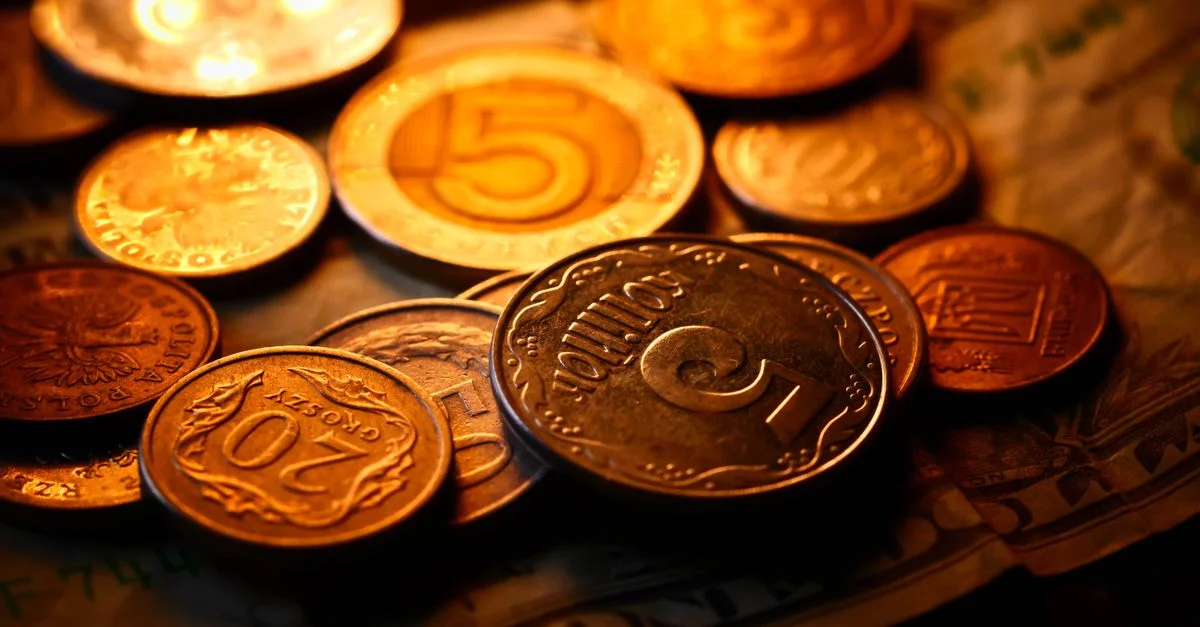 Un primer plano detallado de varias monedas y billetes internacionales con luz cálida, ideal para temas financieros.