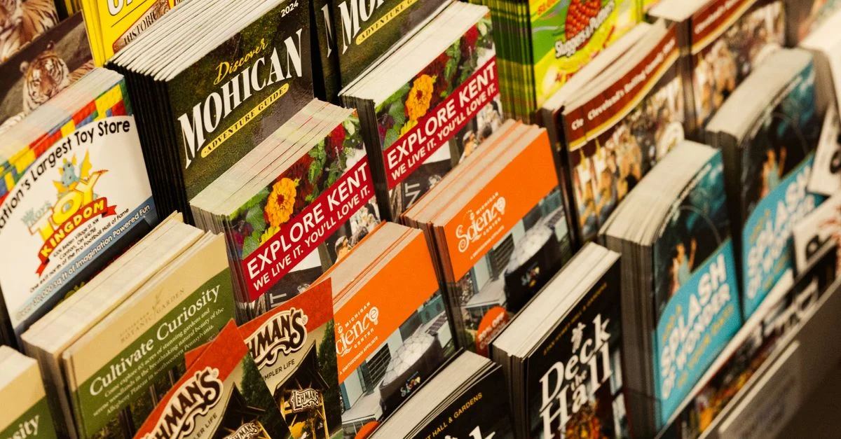 Colorida colección de folletos de viaje en exhibición en una librería.