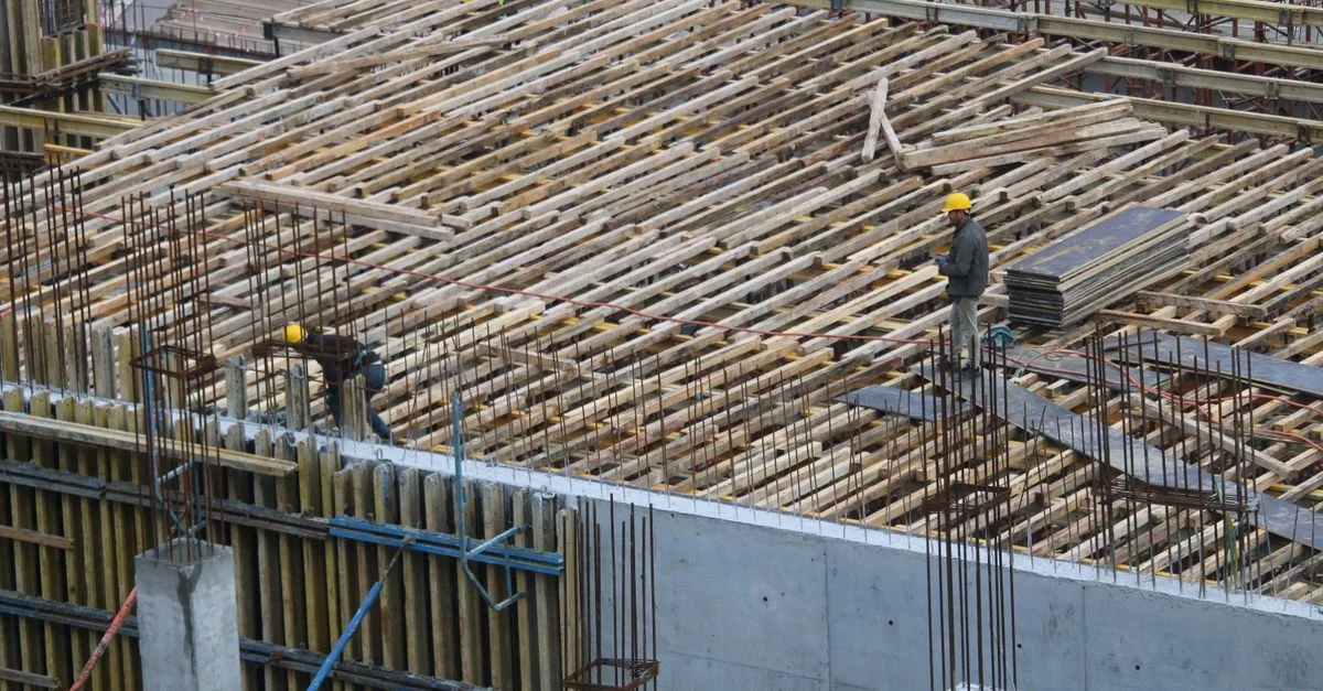 Hombres trabajando en un sitio de construcción en Estambul, con armaduras y estructuras de refuerzo visibles.