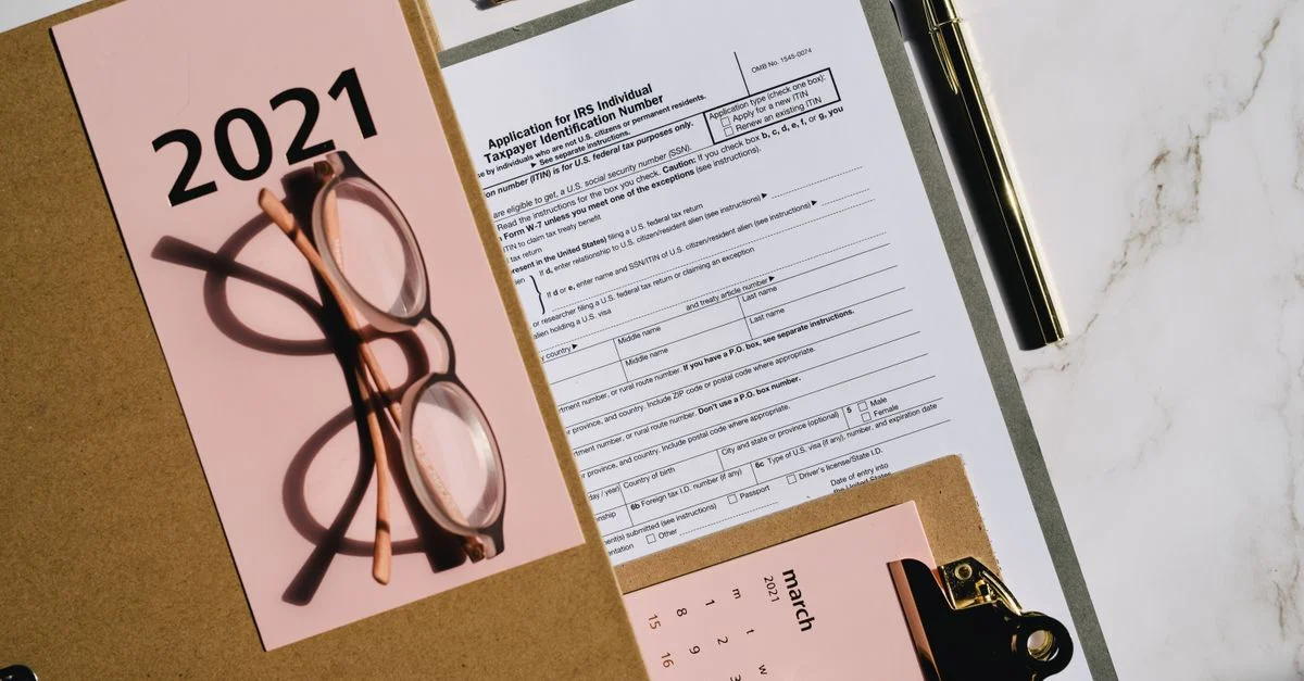 Disposición plana de formularios fiscales, calendario y gafas para la planificación financiera de 2021.